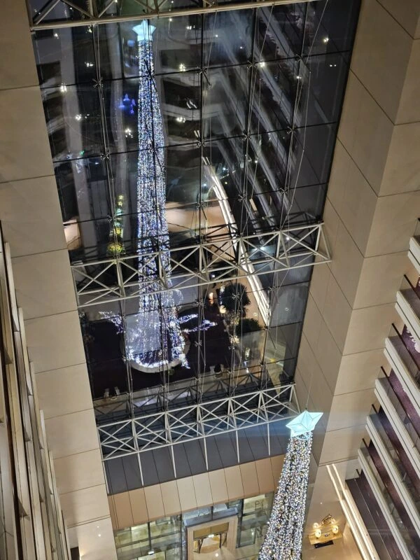 Best aerial view of giant indoor Christmas tree with lights inside luxury hotel.