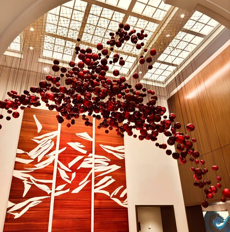 Top artistic red ornament ceiling installation in modern hotel for festive season.