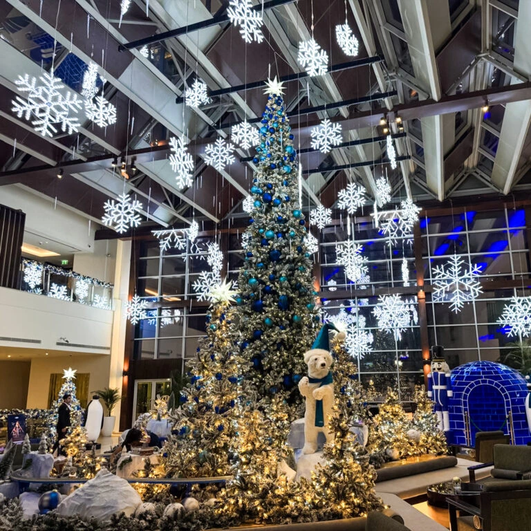 Hotel lobby Christmas display with snowflake lights and polar bear – book festive installation.