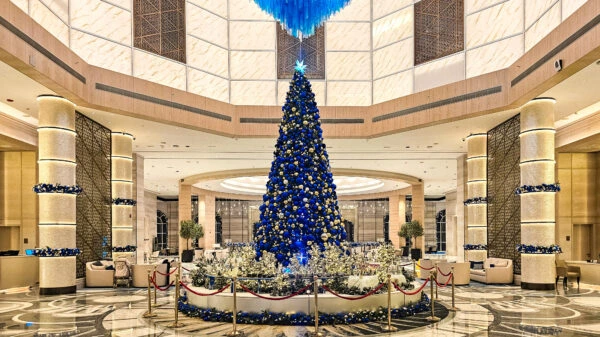 Luxury hotel lobby with grand blue and gold Christmas tree centerpiece