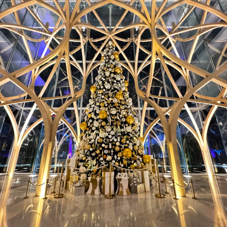 Luxury hotel Christmas tree decoration with gold ornaments book festive décor services all over the world.