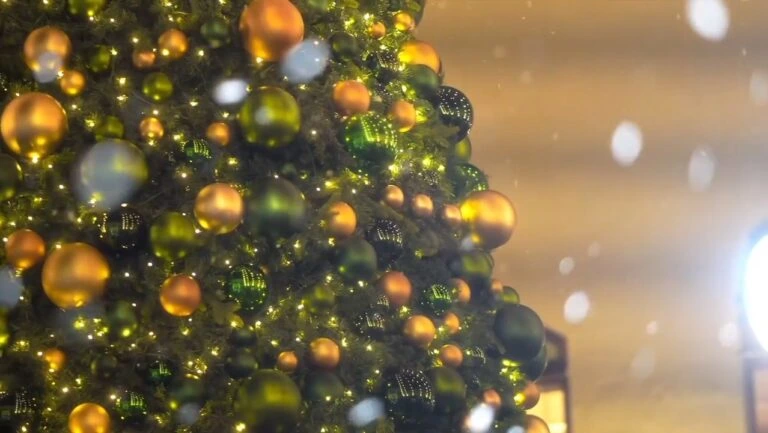 Buy golden and green Christmas ornaments with LED fairy lights for festive tree decorations.