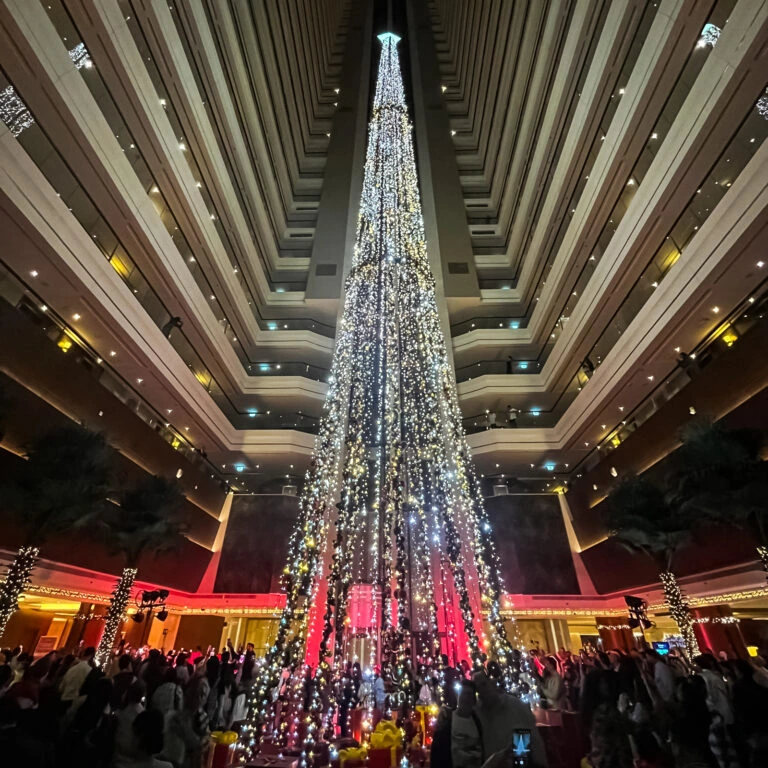 Tallest indoor string light Christmas tree in luxury hotel atrium for holiday celebrations.