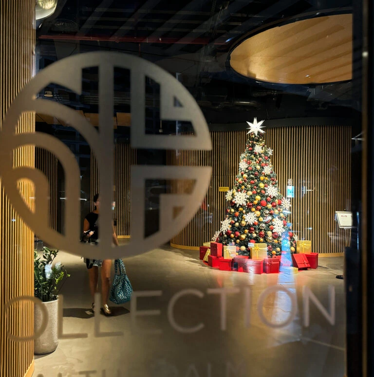 Best Christmas tree view through glass entrance of luxury hotel with gold and red décor