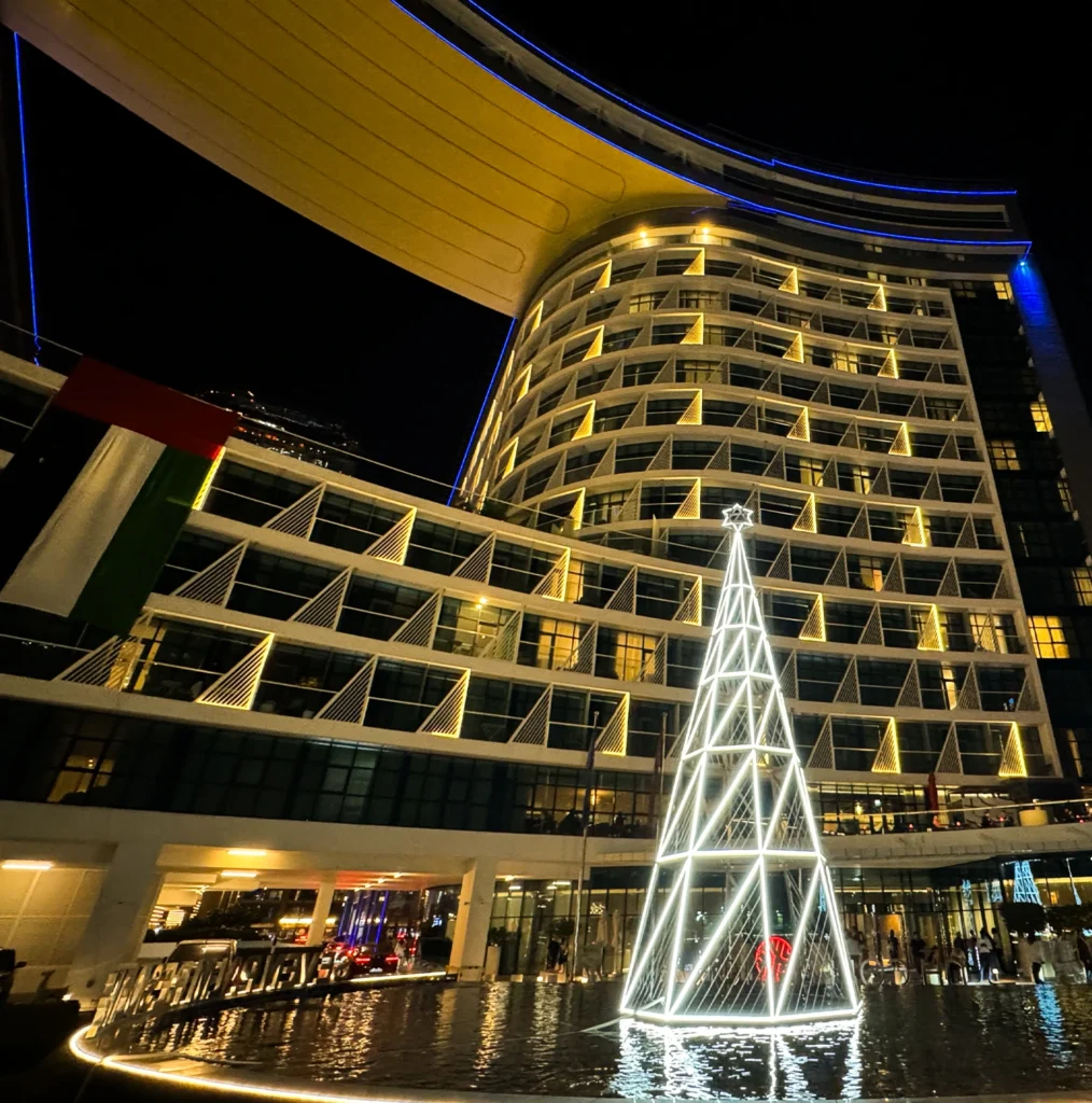 Best outdoor LED Christmas tree at night in front of luxury hotel building.