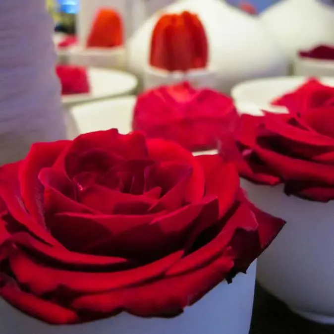 Best floral table arrangement with roses and tulips in modern white vases for events.