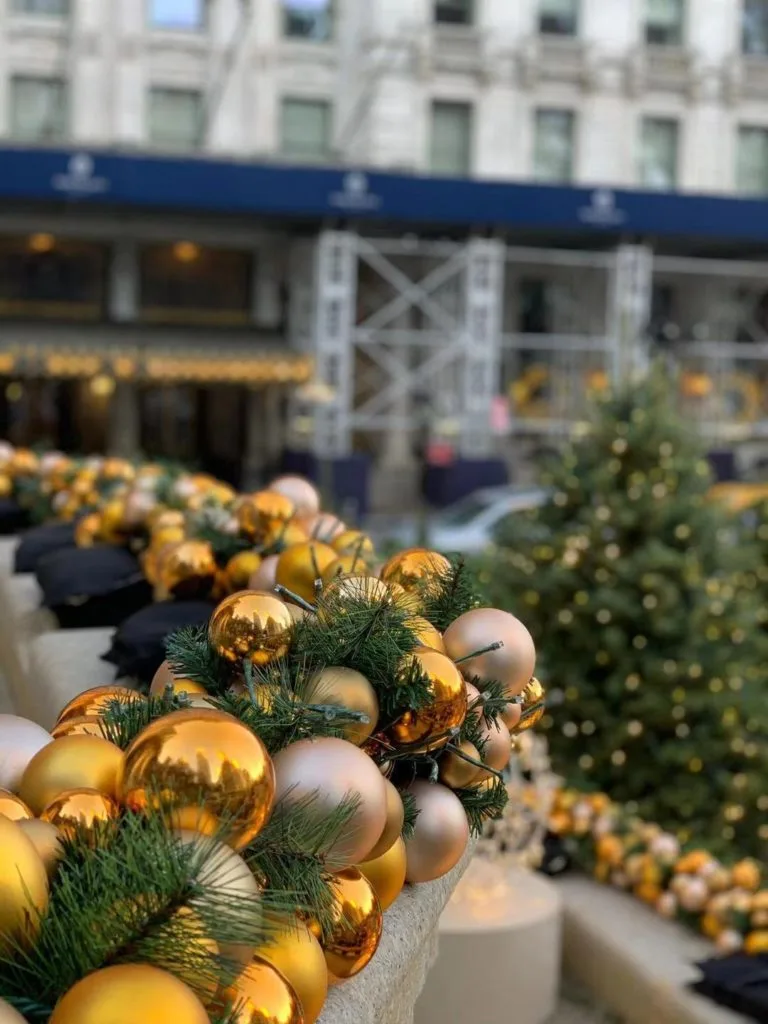 Arrange custom holiday fountain decoration with gold ornaments by The Xmas Designers.