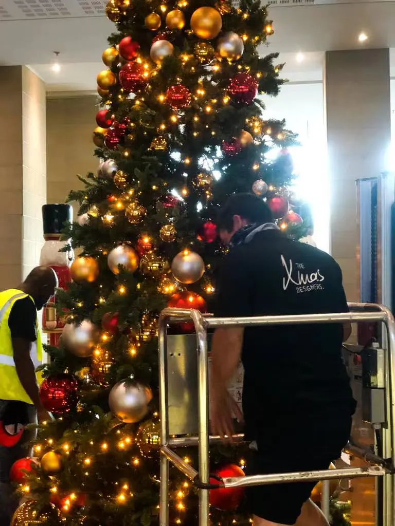 Large festive nutcracker statue placed beside a luxury garland, representing customised Christmas decorations and premium holiday décor.